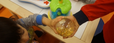 Infants jugant agafant una bola transparent amb les mans