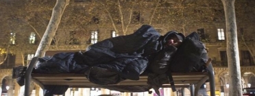 Una persona sense sostre dorm en un banc al costat de la Ciutadella Font: Joan Cortadellas (El Periódico)