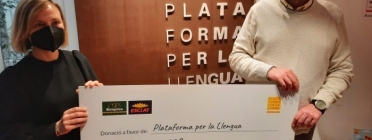 El president de Plataforma per la Llengua, Òscar Escuder, rep el xec amb les donacions per redoblar esforços perquè el català sigui més present a les plataformes de vídeo a la carta. Font: Plataforma per la Llengua