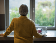 Una persona gran amb Alzheimer observa per la finestra. Font: Fundació Pasqual Maragall
