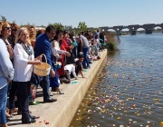 Persones llançant pètals al riu per celebrar el 8 d'abril, Dia Internacional del Poble Gitano Font: Fundación Secretariado Gitano