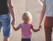 Una família camina, agafant de la mà a la seva filla. Font: Pixabay
