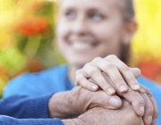 Imatge de les mans d'una persona gran agafades per una cuidadora Font: Fundació ACE