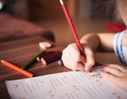 Un infant escrivint i dibuixant amb llapissos de colors. Font: Pixabay