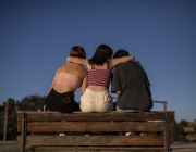 Escena representada: tres noies seuen a un banc donant-se suport. Font: Save The Children