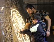 Sam Garcia, de l'Associació Carabutsí, fent un dels nous arcs de llum amb un dels participants. Font: La Traginera