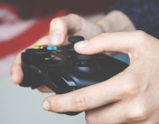Una persona jugant a videojocs amb un comandament a les mans. Font: Pexels (Anton P)