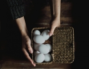 Mans mostrant cistell amb ous blancs. Font: Pexels - Daniela Constantini