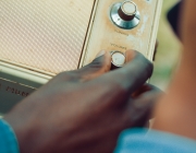 Una persona apujant el volum d'un receptor de ràdio antic. Font: Nicholas Githiri (Pexels)