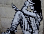 Un graffiti en que apareix una persona jove amb el seu telèfon mòbil. Font: Pixabay
