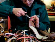 Un dona fabrica sabates en un taller