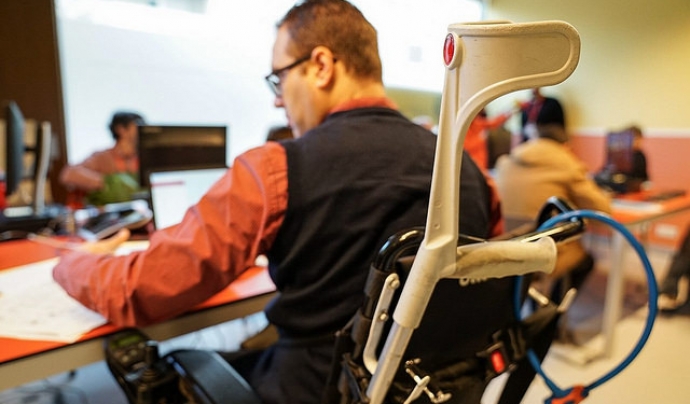 Noi amb cadira de rodes treballant en un ordinador Font: Ajuntament de Barcelona