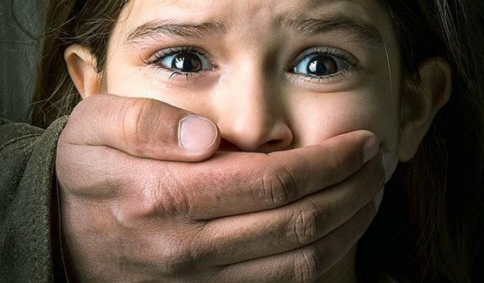 Imatge d’una nena a la que un home li tapa la boca. Font: web abc.es