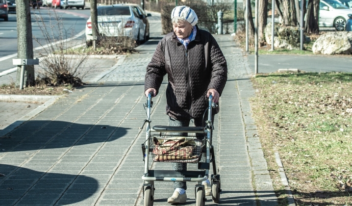 Una persona amb Alzheimer camina pel carrer amb un caminador. Font: Pixabay