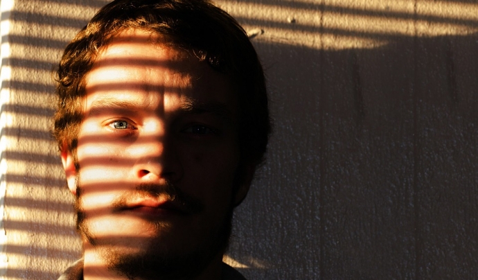 Un home té mitja cara tapada per una ombra. Font: Pixabay