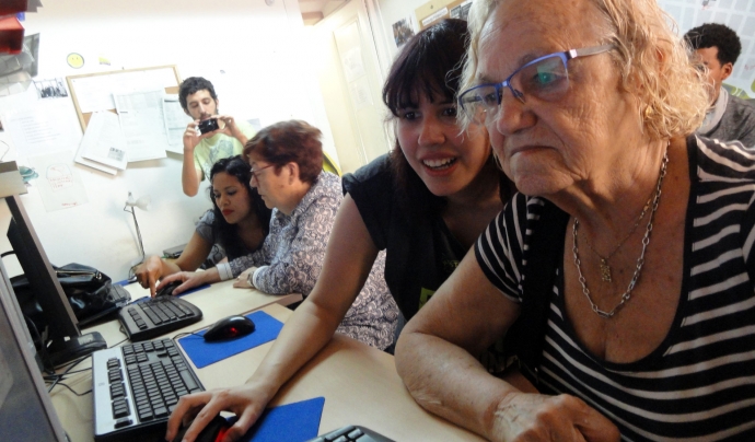 Una jove ensenya a fer servir l'ordinador a una senyora gran