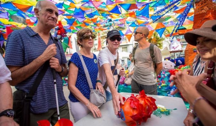 La Festa Major de Gràcia inclou en el programa visites amb audiodescripcions als carrers decorats per a persones amb.discapacitat visual. Font: Fundació Festa Major de Gràcia