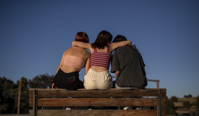 Escena representada: tres noies seuen a un banc donant-se suport. Font: Save The Children
