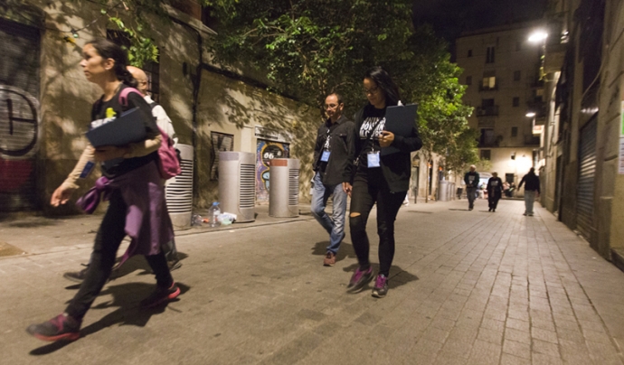 Voluntariat caminant pels carrers de Barcelona durant la nit i enquestant persones que viuen al ras.