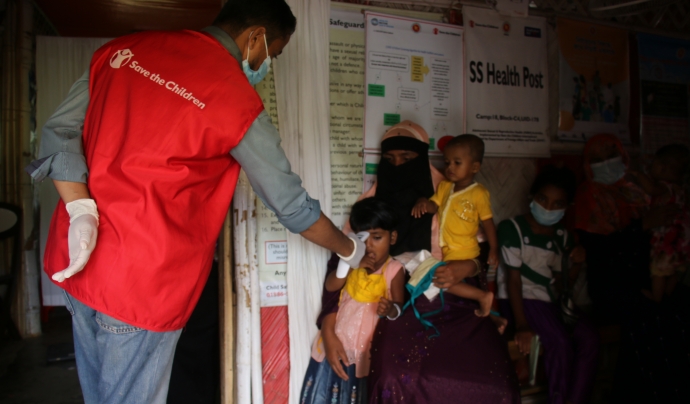 Un dels treballadors humanitaris de Save The Children a Bangladesh, atenent una família de pacients regulars al centre de salut primària de Save the Children al camp de refugiats de Rohingya. Font: Sonali Chakma / Save The Children