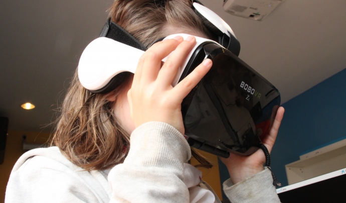 Una de les nenes prova les ulleres de realitat virtual durant la sessió de portes obertes del projecte. Font: Elisenda Pallarés