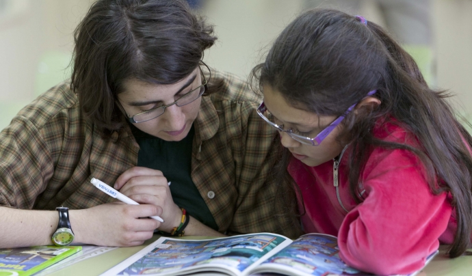 Una voluntària ensenya una nena a llegir