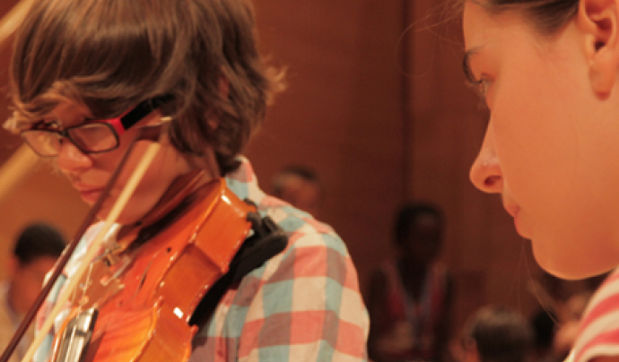 Un nen del centre tocant el violí Font: 