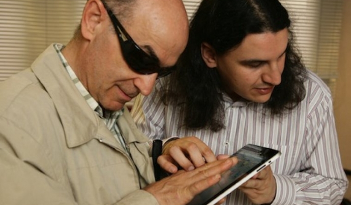 Una persona voluntària acompanyant a una persona amb discapacitat visual, usuària de l'ONCE Font: ONCE