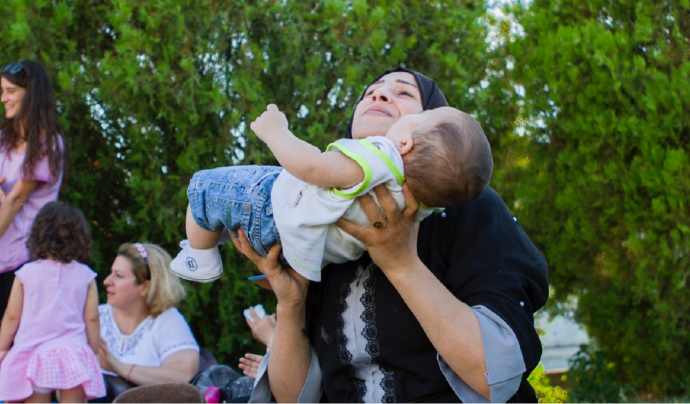 Una mare participant del projecte agafa el seu fill. Font: Open Cultural Center