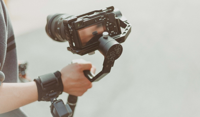 Una persona amb càmera en mà preparada per començar a gravar un pla en moviment. Font: Julia Avamotive (Pexels)