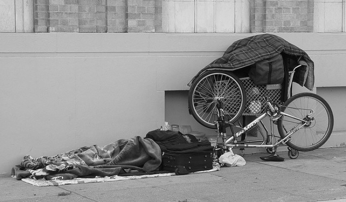 Homeless reading on the sidewalk. Fotografia de l'usuari Flickr Franco Folini Font: 