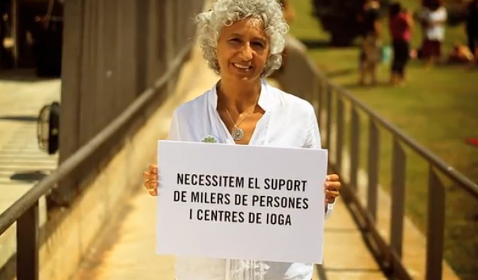 Dona amb cartell del Yoga Day: Necessitem suport! Font: 