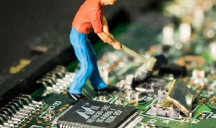 Fotografia d'una persona trencant una placa electrònica