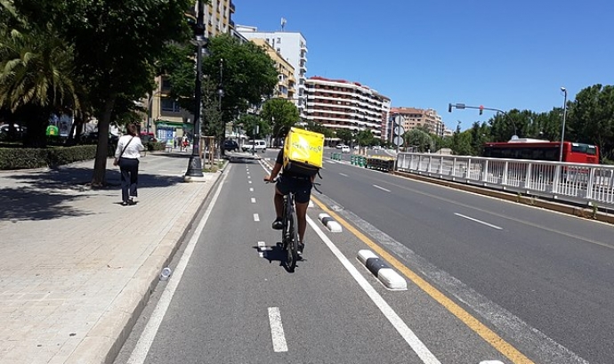 Una persona treballadora de Glovo en bicicleta a València. Font: Pacopac (Wikimèdia Commons)