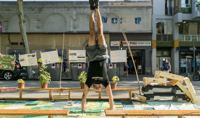 Jove fent equilibris en una plaça del pàrquing al barri de Sant Antoni durant el Park(ing) Day. Font: Marc Gómez