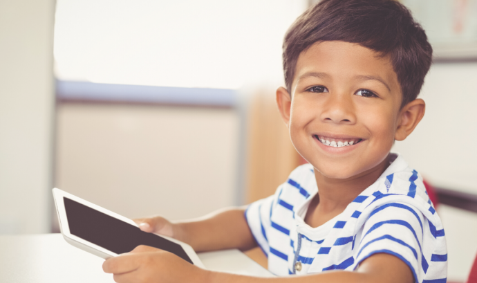 Un nen agafa una tablet a casa per poder continuar amb la seva rutina escolar. Font: Fundació IRES