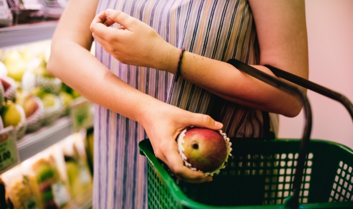 Una dona compra fruita al supermercat.  Font: PxHere