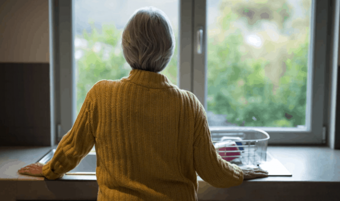 Una persona gran amb Alzheimer observa per la finestra. Font: Fundació Pasqual Maragall