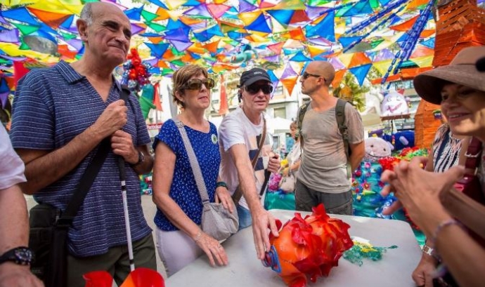 La Festa Major de Gràcia inclou en el programa visites amb audiodescripcions als carrers decorats per a persones amb.discapacitat visual. Font: Fundació Festa Major de Gràcia