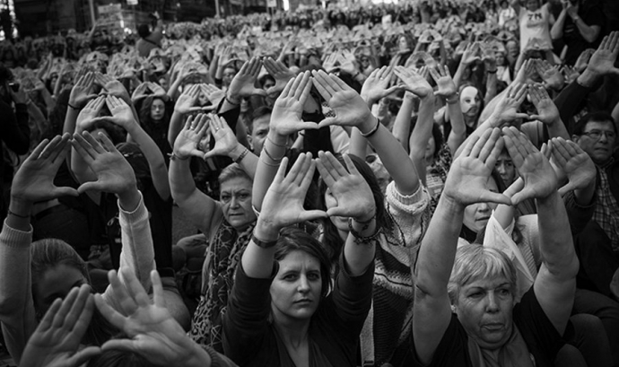 Un grup d'activistes alçant els braços per mostrar el símbol feminista Font: Twitter de Dones Juristes