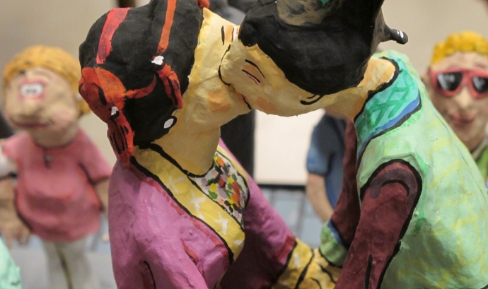 Dos gegants fent-se un petó a l'exposició ‘Gegants, humor, fantasia i realitat'