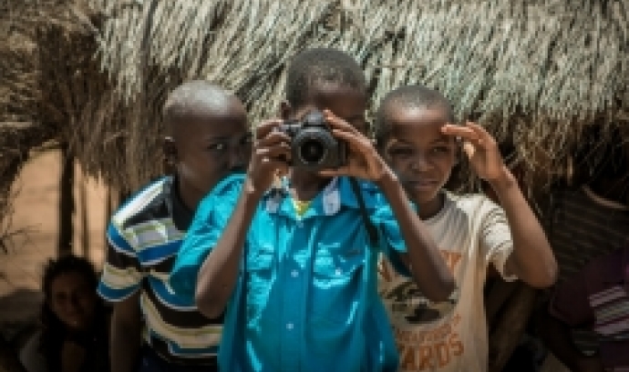 Tres nens i un d'ells amb una càmera reflexi Nikon. Font: Martin Bekerman