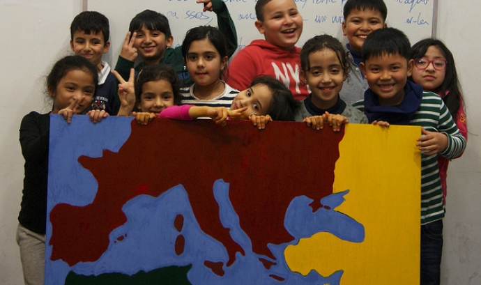 Els nens i nenes que participen al projecte mostren un mapa que han creat Font: 
