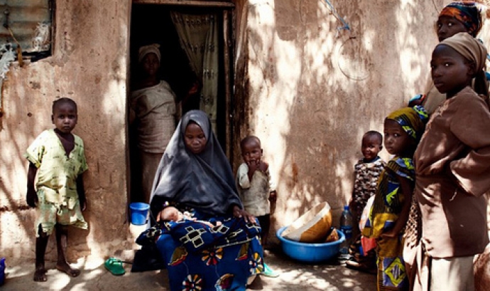 Persones davant d'una casa a Nigèria. Font: Gates Foundation (Flickr)