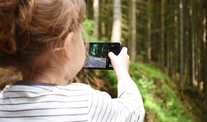 Una nena fa una fotografia al paisatge amb un mòbil. Font:  Anviere (Pixabay)