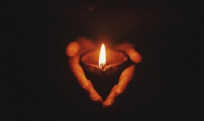 Espelma encesa sostinguda per una mà. Font: Prateek Gautam