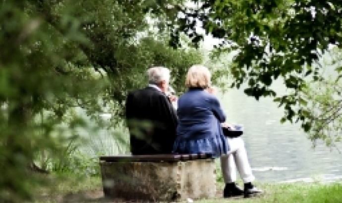 Home i dona grans asseguts davant d'un llac. Font: Sven Miekel