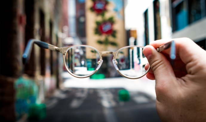 Una persona subjecta unes ulleres al mig del carrer. Font: Unsplash