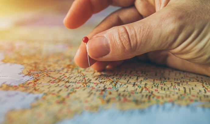 Una mà que marca un punt en el mapa amb una agulla. Font: Piviso (Pixabay)