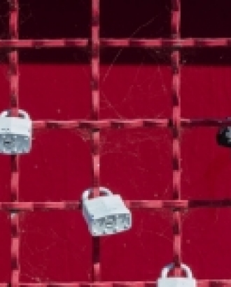 Diversos cadenats sostinguts en una reixa vermella. Font: Jon Moore